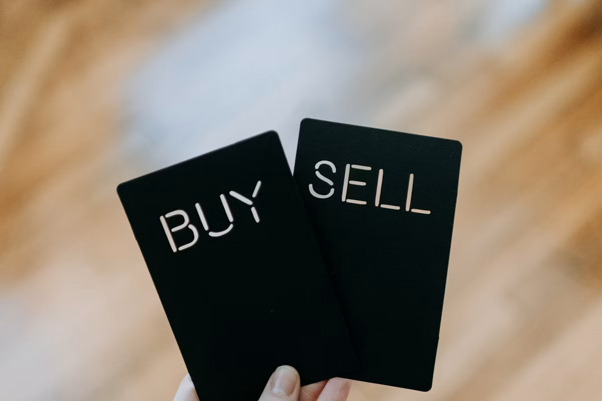 Hand holding buy and sell cards representing sector positioning
